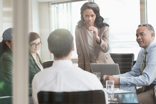 Businesswoman talking to colleagues in meeting - Grooa