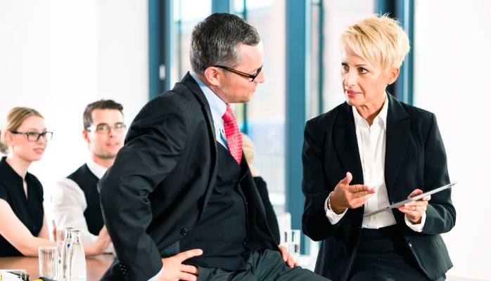Coworkers wearing black suit in a conversation