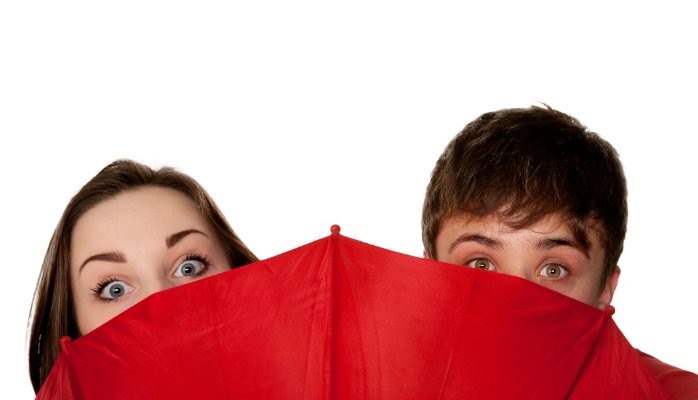 A woman and a man behind a red umbrella